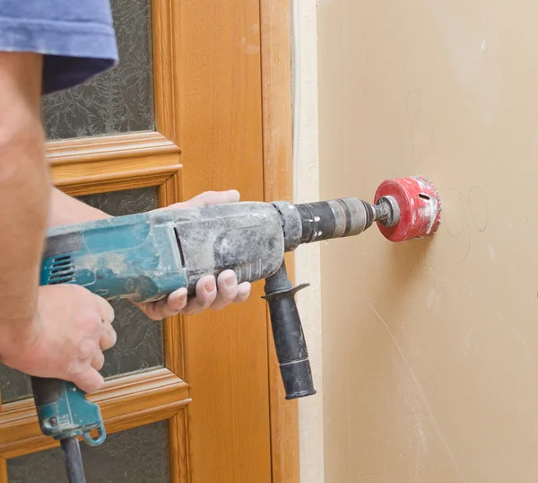 Man with Hammer drill doing hole for socket. — Stock Photo, Image