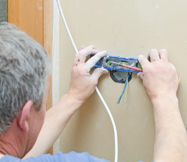 Eletricista certificado instalando soquete para interruptor de luz . — Fotografia de Stock