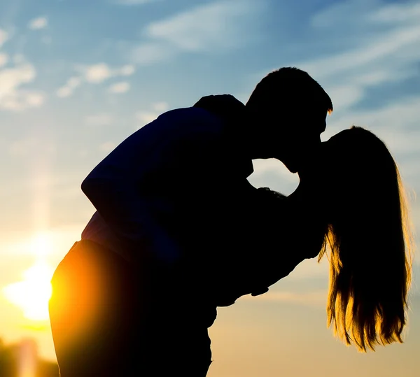 Mladý pár se těší na západ slunce. dvě siluety. — Stock fotografie