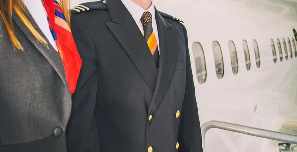 Pilot och flygvärdinna nära flygplanet. — Stockfoto