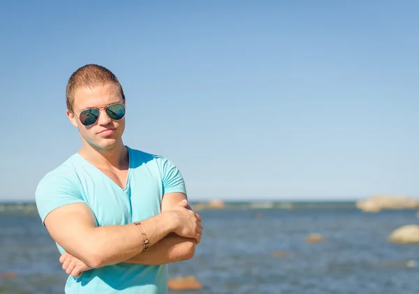 Homem atraente muscular em óculos perto do mar . — Fotografia de Stock