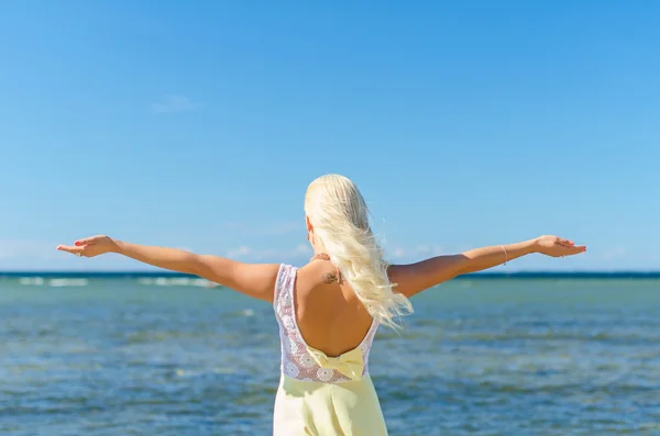 Ung kvinna med armarna vidöppna nära havet. plats för text. — Stockfoto