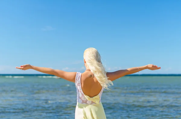 Mujer joven con los brazos abiertos cerca del mar. Lugar para el texto . — Foto de Stock