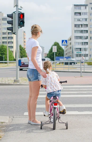 Madre e hija con bicicleta en el cruce de cebra . — Foto de Stock