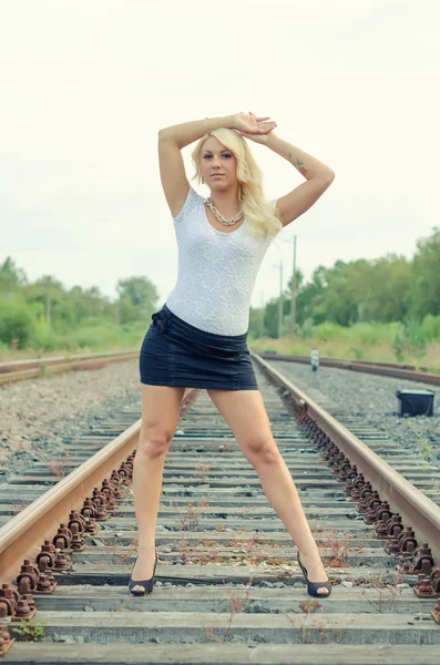 Attraktive blonde Frau posiert auf der Eisenbahn. — Stockfoto