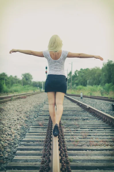 Ελκυστική ξανθιά γυναίκα που παρουσιάζουν στον σιδηροδρομικό. — Φωτογραφία Αρχείου