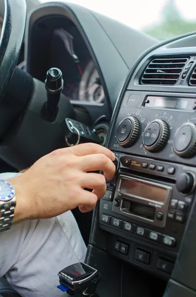 La mano del hombre sintonizando la radio en el coche . — Foto de Stock