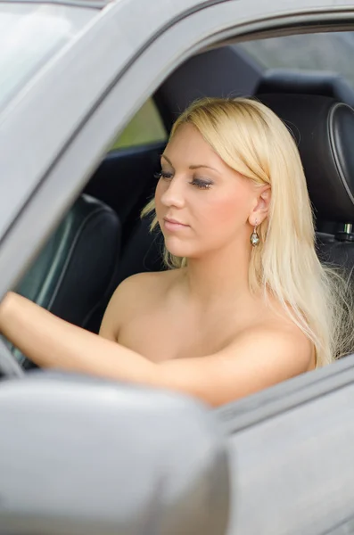 Mujer bastante rubia conduciendo un coche . — Foto de Stock