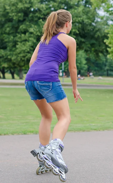 Vrouw is schaatsen rollerblades in het park. — Stockfoto
