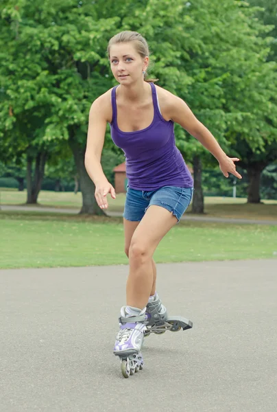 La mujer patina patines en el parque . — Foto de Stock