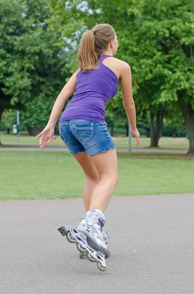 La mujer patina patines en el parque . — Foto de Stock