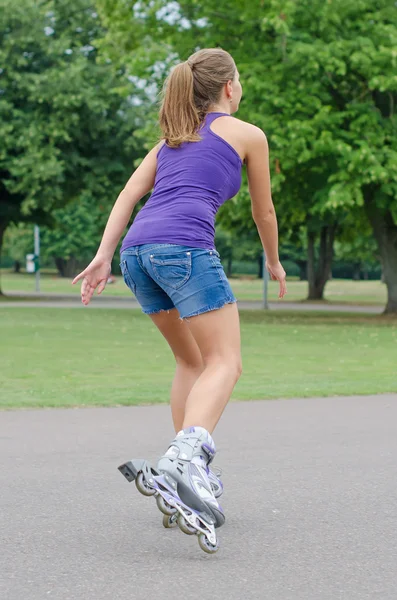 La donna sta pattinando sui pattini nel parco . — Foto Stock