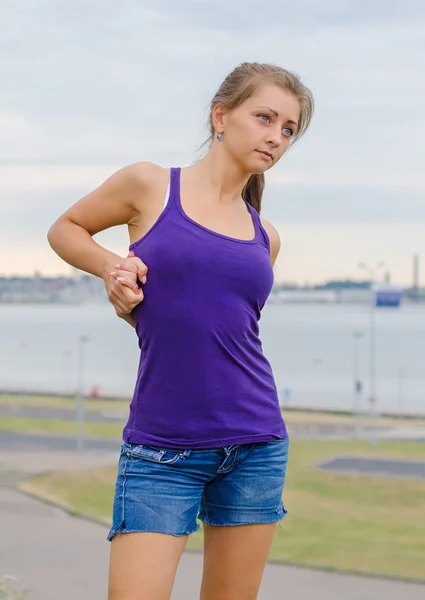 Mladá žena se táhne před sportovním. — Stock fotografie