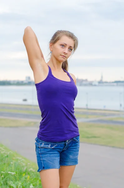 Mujer joven se estira antes de hacer deporte . — Foto de Stock