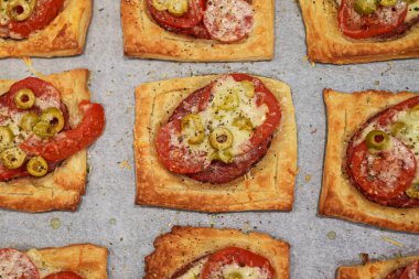 Salamlı, peynirli, zeytinli ve domatesli fırında mini pizza..