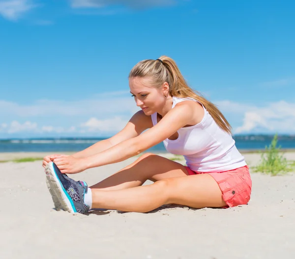 Mujer joven se estira antes de hacer deporte . —  Fotos de Stock