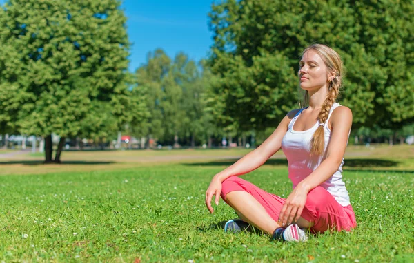 Giovane donna che fa yoga nel parco. — Foto Stock