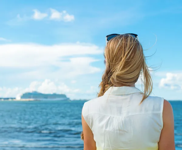 女性は、海のそばに立っていると、船を待っています。. — ストック写真