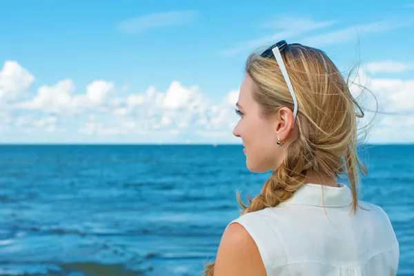 女性は、海のそばに立っていると、船を待っています。. — ストック写真