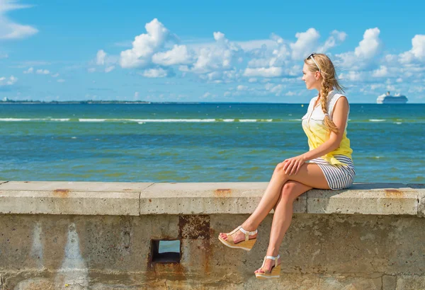 Kobieta siedzi w pobliżu morza i czeka na statku. — Zdjęcie stockowe