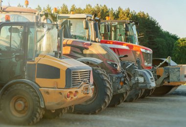 Otoparkta yol yapım makineleri var. Patenler ve traktörler.