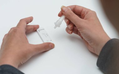 Kadın evinde COVID-19 antijen testi yapıyor..