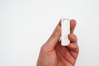 Elinde COVID-19 antijen testi tutan adam..