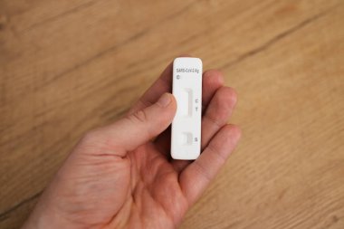 Elinde COVID-19 antijen testi tutan adam..