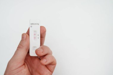 POSITIVE Ekspres COVID-19 antijen testi tutan adam.