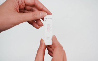 POSITIVE Ekspres COVID-19 antijen testi yapan kadın.