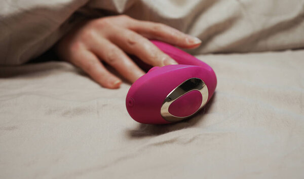 Woman taking pulse vibrating g-spot stimulator.