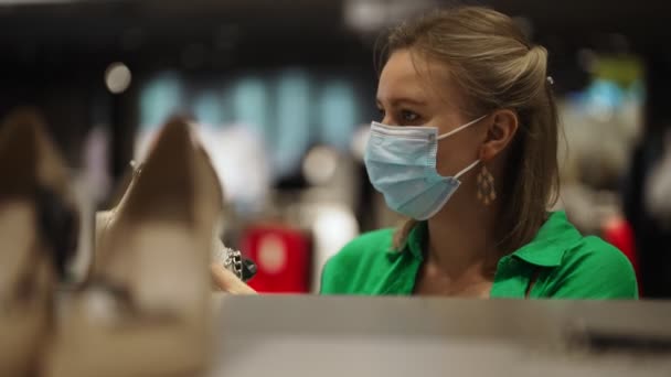 Vrouw Met Medisch Masker Kiest Handtas Winkel — Stockvideo