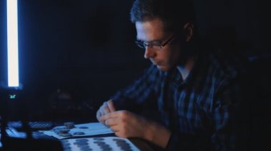 Erkek numismatist madeni para koleksiyonunu inceliyor.