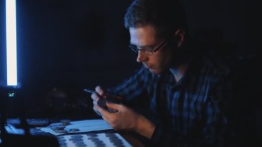 Erkek numismatist madeni para koleksiyonunu inceliyor.