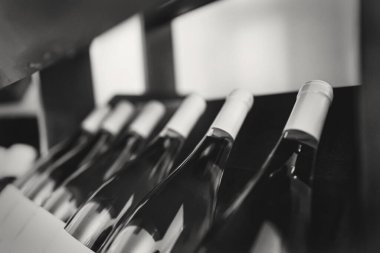 Ahşap raflarda istiflenmiş şarap şişeleri..