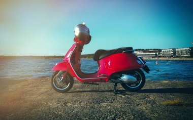 Deniz kıyısında kırmızı renkli scooter..