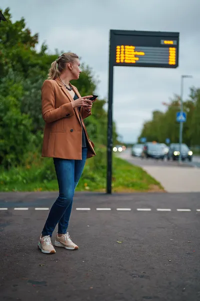 Mujer Con Teléfono Inteligente Está Esperando Autobús Parada Autobús — Foto de Stock