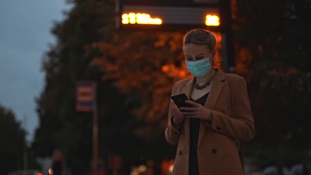 Kvinna Medicinsk Mask Med Smartphone Väntar Bussen — Stockvideo