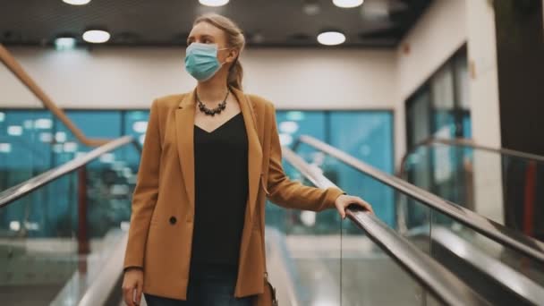 Mulher Máscara Médica Monta Uma Escada Rolante Shopping Center — Vídeo de Stock