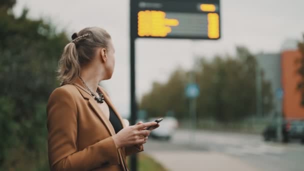 Mujer Con Teléfono Inteligente Está Esperando Autobús Parada Autobús — Vídeo de stock