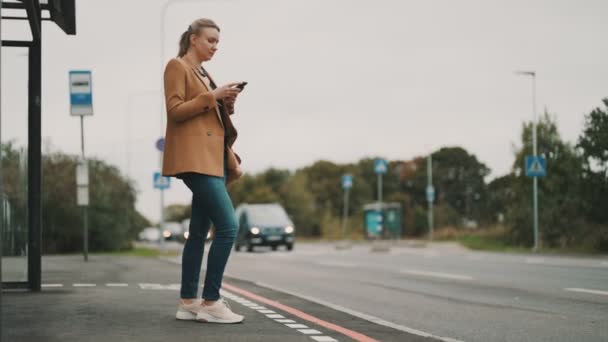 Femeie Smartphone Așteaptă Autobuzul Stația Autobuz — Videoclip de stoc
