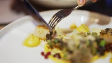 Kadın lokantada deniz tarağı yiyor..