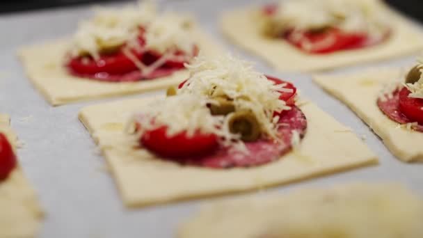 Backen Von Quadratischen Minipizzen Mit Salami Käse Oliven Und Tomaten — Stockvideo