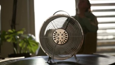 Evdeki havalandırma pervanesinin önündeki kadın..