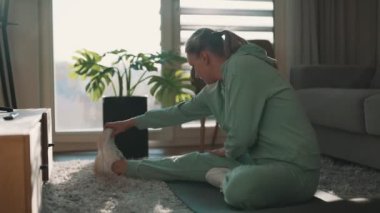 Esneme egzersizleri yapan bir kadın. Evde fitness eğitimi kavramı.