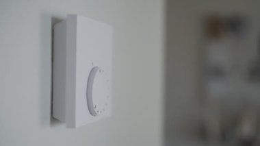 Kadın ısınmak için ısıtma termostatını açıyor..