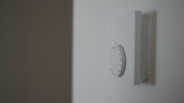 Kadın ısınmak için ısıtma termostatını açıyor..