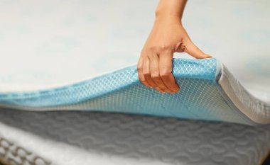 Woman hand testing orthopedic memory foam mattress topper. clipart