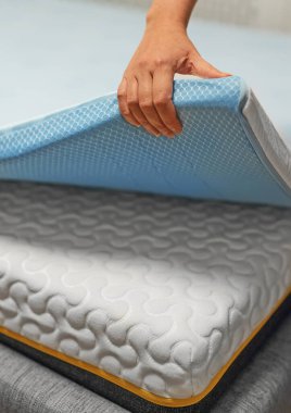 Woman hand testing orthopedic memory foam mattress topper. clipart