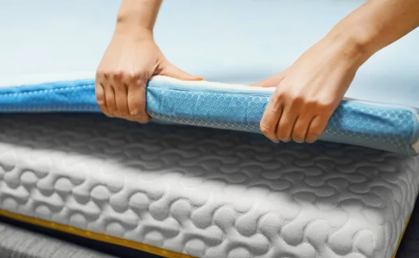 Woman hand testing orthopedic memory foam mattress topper.